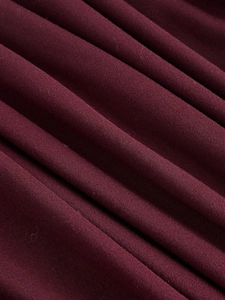 Detailed macro view of the pleated wine red fabric showing texture and soft drape