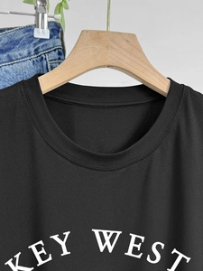 Women's black cotton crew neck T-shirt with white Key West graphic print on wood hanger