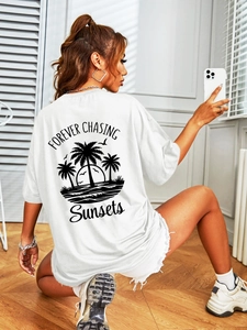 Detail of white cotton oversized T-shirt with palm tree sunset print and sunset text