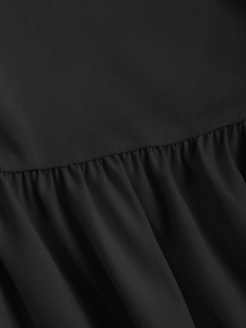 Vue détaillée des volants plissés et de la texture du tissu de la robe noire
