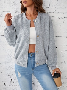 Detail of grey knitted jacket showing gold buttons and textured quilted fabric on sleeve