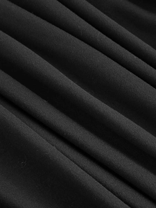 Detail showing the pleated black fabric texture and soft drape of the V-neck dress