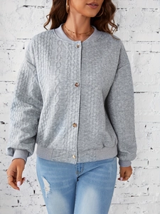 Detail of grey quilted knit jacket texture with metal buttons and ribbed cuffs for women