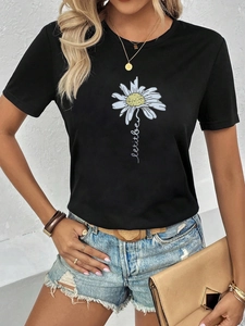 Detail von Gänseblümchen-Druck und 'let it be' Text auf schwarzem Baumwoll-T-Shirt