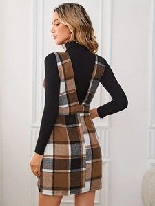 Détail d'une robe gilet à carreaux vintage avec dos en V sur un pull en maille noir