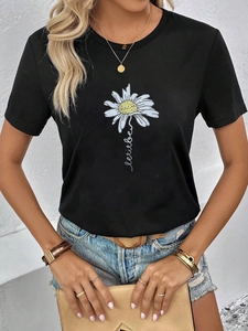Detail von weißem Gänseblümchen-Druck und Let it be-Text auf schwarzem Baumwoll-T-Shirt