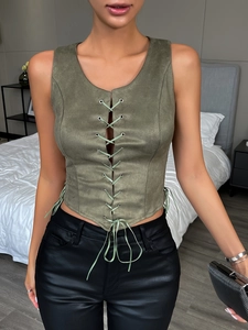 Dettaglio del gilet scamosciato verde militare con occhielli metallici e lacci bohémien