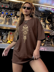 Détail de l'imprimé papillon et phases de lune sur un t-shirt marron foncé ample