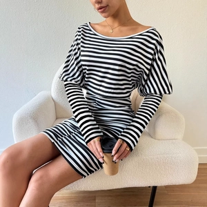 Robe courte rayée moulante avec manches bouffantes et fronces sur canapé blanc