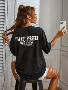 Close-up of black oversized cotton t-shirt featuring white inspirational back print