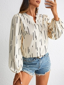 Detail of elegant V-neck beige striped shirt with lantern sleeves and textured fabric