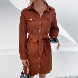 Detailed close-up of brown corduroy shirt dress with lapel collar and waist belt