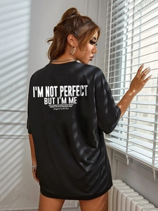 Oversized black cotton T-shirt with white back lettering shown in artistic window light