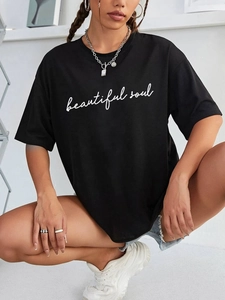 Détail de l'imprimé blanc 'beautiful soul' sur un t-shirt noir oversize en coton