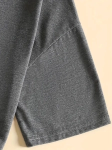Detailed macro view of dark grey knit fabric with neat double-needle stitching quality