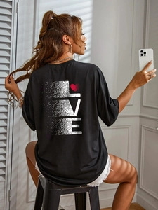 Detail of oversized black T-shirt featuring a white pixelated LOVE print and a red heart