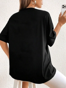 Vista posteriore di una t-shirt nera oversize a girocollo che mostra il tessuto liscio