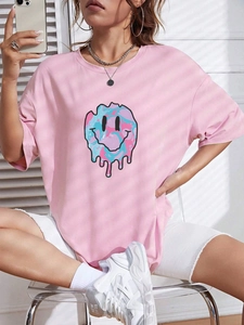 Detail of pink oversized t-shirt featuring a melting smiley face print with fluid colors