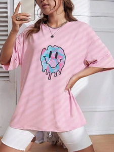 Detail of pink loose T-shirt featuring a colorful melting smiley face print and crew neck