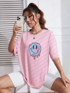 Detail view of pink oversized t-shirt featuring a melting smiley face artistic print