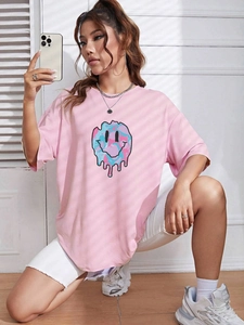 Close-up of pink oversized T-shirt with a colorful melting smiley face graphic print