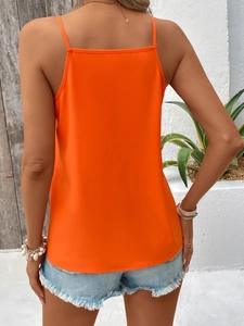 Detail of bright orange spaghetti strap camisole back with high-rise denim shorts