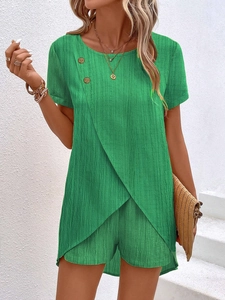 Detailed view of emerald green short sleeve set featuring crossover hem and decorative buttons
