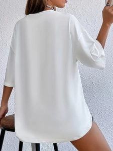 Detail of white loose-fit cotton t-shirt with drop shoulder and high-quality knit texture