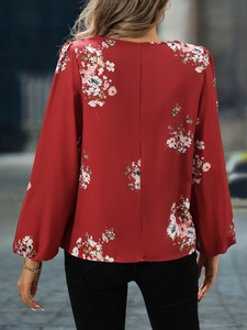Detail einer floralen Damenbluse mit Laternenärmeln und elegantem Rückennaht-Design