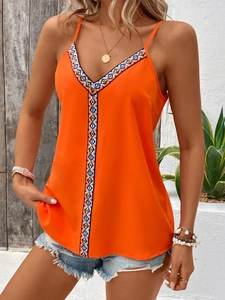 Detail of orange V-neck camisole featuring ethnic geometric patterns and light fabric