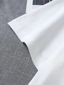 Close-up detail of white cotton T-shirt sleeve with high-quality stitching and fabric texture