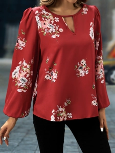 Detail der roten Blumenbluse mit Laternenärmeln und elegantem V-Ausschnitt