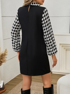 Detail view of the back design on an elegant houndstooth patchwork long sleeve dress