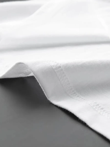 Detailed close-up of white cotton fabric showing high-quality stitching and seam work