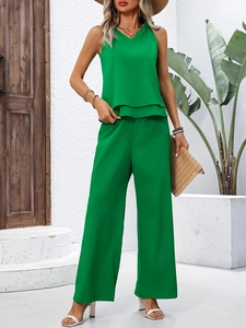 Detail of emerald green sleeveless tiered top and high-waisted wide-leg trousers set