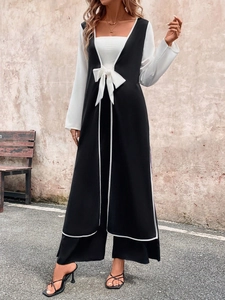 Detail of contrast binding and elegant waist tie on long sleeveless open cardigan