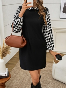 Detail of elegant black dress with houndstooth patterned lantern sleeves and round collar