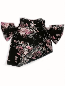 Detalle de blusa floral con hombros descubiertos y cierre de botón en espalda