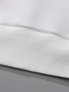 Macro view of white ribbed hem and high-quality stitching on a cotton sweatshirt