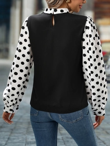 Detail of polka dot long sleeves and back button closure on an elegant women shirt