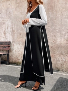 Detail of color block long sleeve dress with side slit and contrast piping decoration