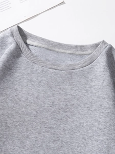 Close-up of crew neck with ribbed stitching and warm fleece lining on a grey sweatshirt