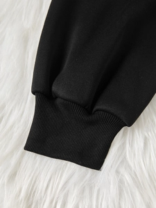 Detailed macro view of the elastic ribbed cuffs on this black floral long sleeve top