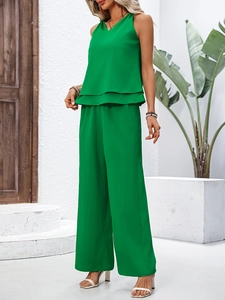 Detail of green sleeveless top and wide-leg pants showing the crepe fabric texture