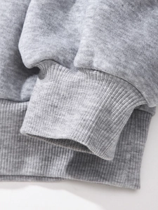 Macro shot of ribbed cuffs and hem detail on a grey owl printed knit sweatshirt