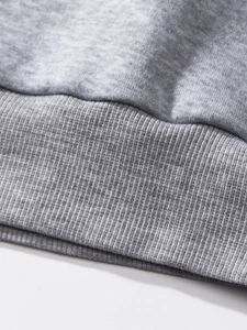 Detail of marl grey knit fabric showing high-quality ribbed hem and fine texture
