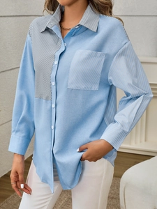 Detail of blue paneled shirt with striped collar, chest pocket and casual button-up design