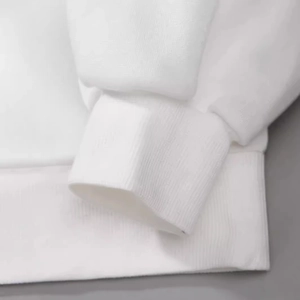 Close-up of white long sleeve sweatshirt with ribbed cuffs and soft cotton knit texture