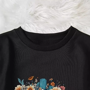 Sweatshirt noir femme à imprimé floral et col rond côtelé sur un tapis en peluche doux