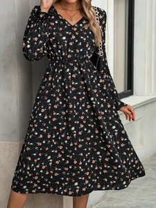 Détail d'une robe fleurie noire élégante avec col en V et taille haute élastique